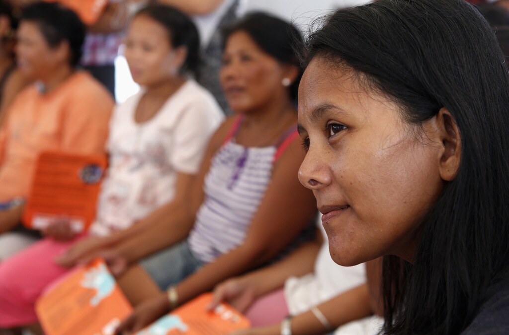 Women survivors of super typhoon Haiyan listen during a lecture on the prevention of gender-based violence by United Nations Population Fund (UNFPA) volunteer in Tacloban city in central Philippines December 14, 2013. Based on national data in the eight affected provinces prior to the disaster, an estimated 375,000 women and girls aged 15-49 would have experienced sexual violence in their lifetime. This number could increase by 75,000 without adequate protection measures, UNFPA said in a statement. REUTERS/Erik De Castro (PHILIPPINES - Tags: DISASTER HEALTH) - GM1E9CE1FG601