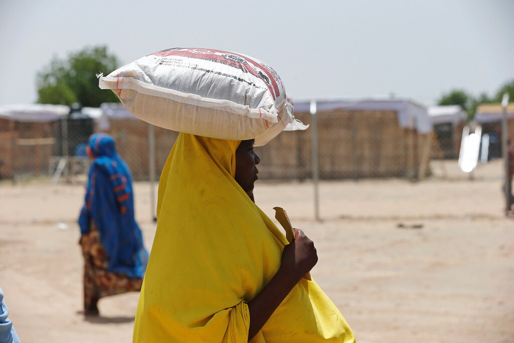 A woman carries a bag of rice during a food rationing at an internally displaced persons (IDP) camp on the outskirts of Maiduguri, northeast Nigeria June 6, 2017. REUTERS/Akintunde Akinleye - RC165CC1FF10