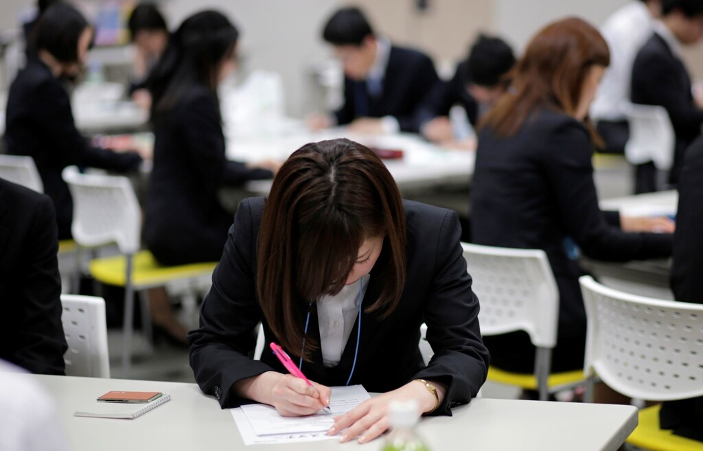 Japanese job-hunting students dressed in suits attend a business manners seminar at a placement centre in Tokyo May 28, 2012.