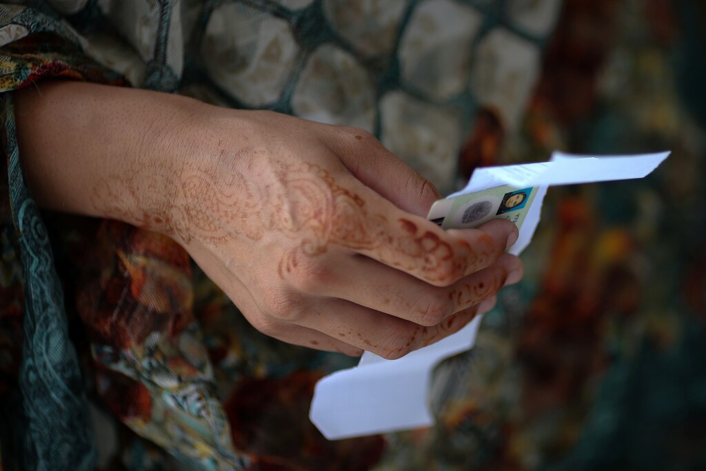 A voter holds up her national identity card as she waits to enter a polling station during general election in Islamabad, Pakistan, July 25, 2018. REUTERS/Athit Perawongmetha