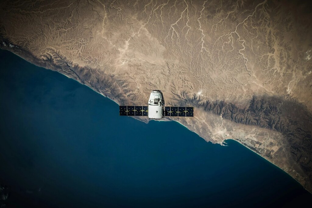 Un Satélite avanza sobre la costa. Utilizamos satélites y otras tecnologías para vigilar y observar la salud de la Tierra.