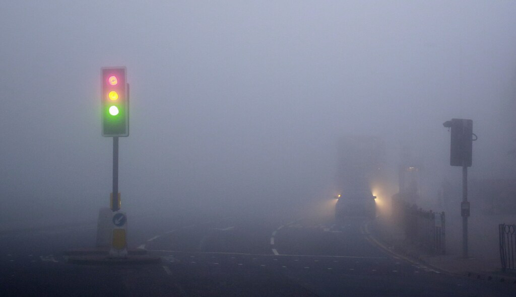 Traffic lights are seen in early morning thick fog in London March 13, 2014. Flights have been cancelled at London City airport and Heathrow, the Woolwich ferry has been cancelled, and low visibility has caused slow traffic on motorways. REUTERS/Russell Boyce (BRITAIN - Tags: ENVIRONMENT TRANSPORT TPX IMAGES OF THE DAY) - GM1EA3D16LS01