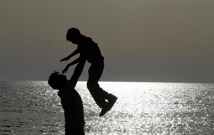 A father plays with his son on a beach facing the Adriatic sea, near the city of Durres, some 40 km (25 miles) from Tirana April 28, 2013. REUTERS/Arben Celi (ALBANIA - Tags: SOCIETY)