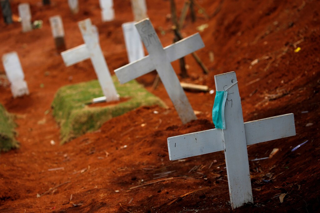 A protective mask hangs on a cross at the burial area provided by the government for victims of the coronavirus disease (COVID-19) at Pondok Ranggon cemetery complex, as the outbreak continues in Jakarta, Indonesia, September 24, 2020. REUTERS/Willy Kurniawan TPX IMAGES OF THE DAY - RC2W4J9XZGCO