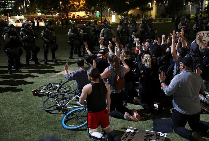 Demonstrators raise their hands as they wait for LASD officers to detain them during a protest in response to the death in Minneapolis police custody of George Floyd, in Los Angeles, California, U.S., June 3, 2020. Picture taken June 3, 2020. REUTERS/Patrick T. Fallon