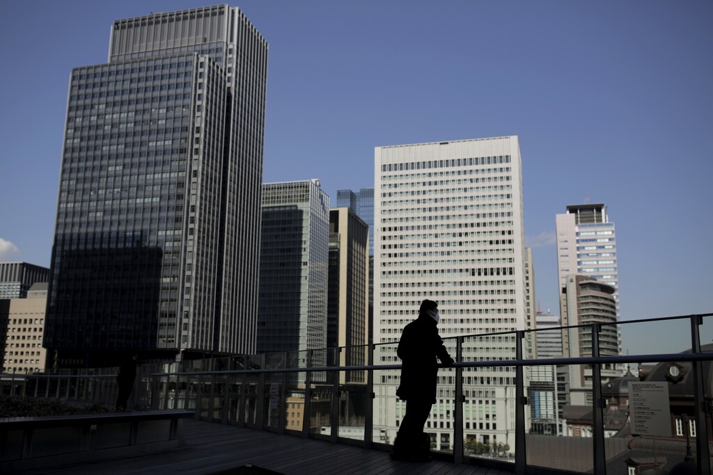A businessman stands on a terrace overlooking a banking district in Tokyo, Japan, February 16, 2016. The Bank of Japan's negative interest rates came into effect on Tuesday in a radical plan already deemed a failure by financial markets, highlighting Tokyo's lack of options to spur growth as global markets sputter. REUTERS/Thomas Peter - RTX273XA