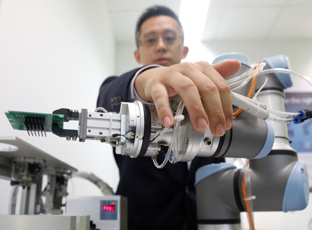A Universal Robots employee demonstrates how a model of their industrial robot arms works in Singapore March 3, 2017.
