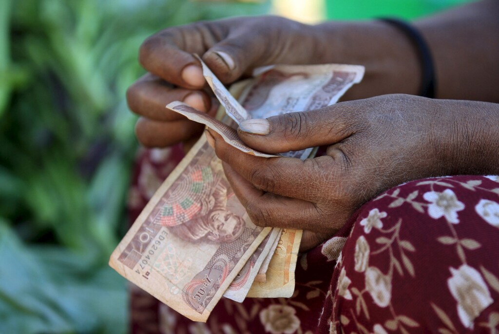 A woman counts Ethiopian birr notes, after selling a cabbage at the Mercato market in Addis Ababa November 14, 2015. Addis Ababa's 'Mercato' - Italian for 'market' - is reputedly the biggest open-air market in Africa, lying in the west of the capital. Supermarkets have sprouted across the city as the metropolis has expanded with Ethiopia's booming economy, but Mercato remains a popular destination for shoppers seeking clothing, electronics and a huge range of other items. It has been around for as long as the city, which was founded at the end of the 19th century, but it took its current form, and its name, from the Italians who invaded Ethiopia in 1935. The Italian occupation ended in 1941. Picture taken November 14, 2015. REUTERS/Tiksa Negeri - GF10000267960