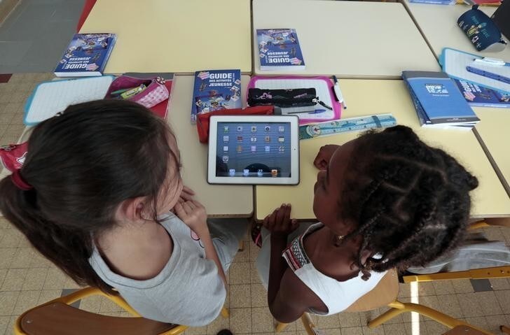 Elementary school children share an electronic tablet on the first day of class in the new school year in Nice, September 3, 2013. REUTERS/Eric Gaillard (FRANCE - Tags: EDUCATION)