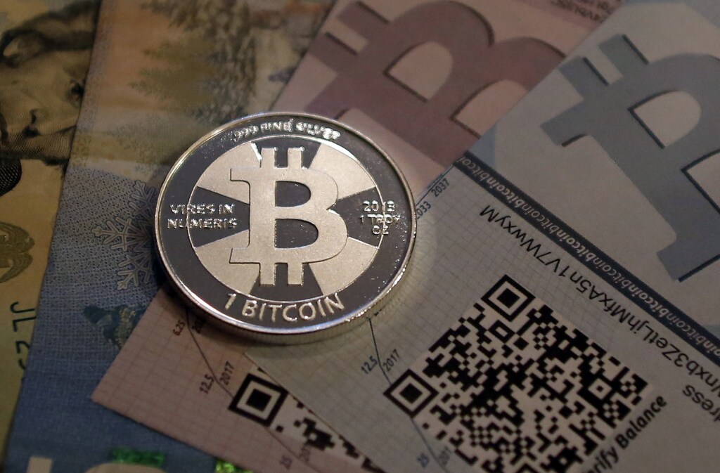 One of Bitcoin enthusiast Mike Caldwell's coins in this photo illustration at his office in Sandy, Utah, September 17, 2013. Bitcoins, touted by some experts as the future of money, gained in prominence during Europe's financial crisis as more people questioned the safety of holding their cash in the bank. Cameron and Tyler Winklevoss, currently making headlines with plans to launch a Bitcoin fund, said on Tuesday that they could see the digital currency becoming a country's official money. REUTERS/Jim Urquhart (UNITED STATES - Tags: BUSINESS SOCIETY) - RTX13QBQ