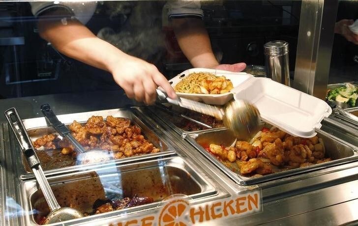 An employee handles a customer's takeout order at a Panda Express restaurant in Los Angeles, California May 20, 2010. Panda Express, the largest Asian-themed restaurant company in the United States, is accelerating unit growth as a healing U.S. economy drives more diners into its nearly 1,300 quick-service outlets. Picture taken May 20, 2010. REUTERS/Fred Prouser (UNITED STATES - Tags: BUSINESS FOOD)
