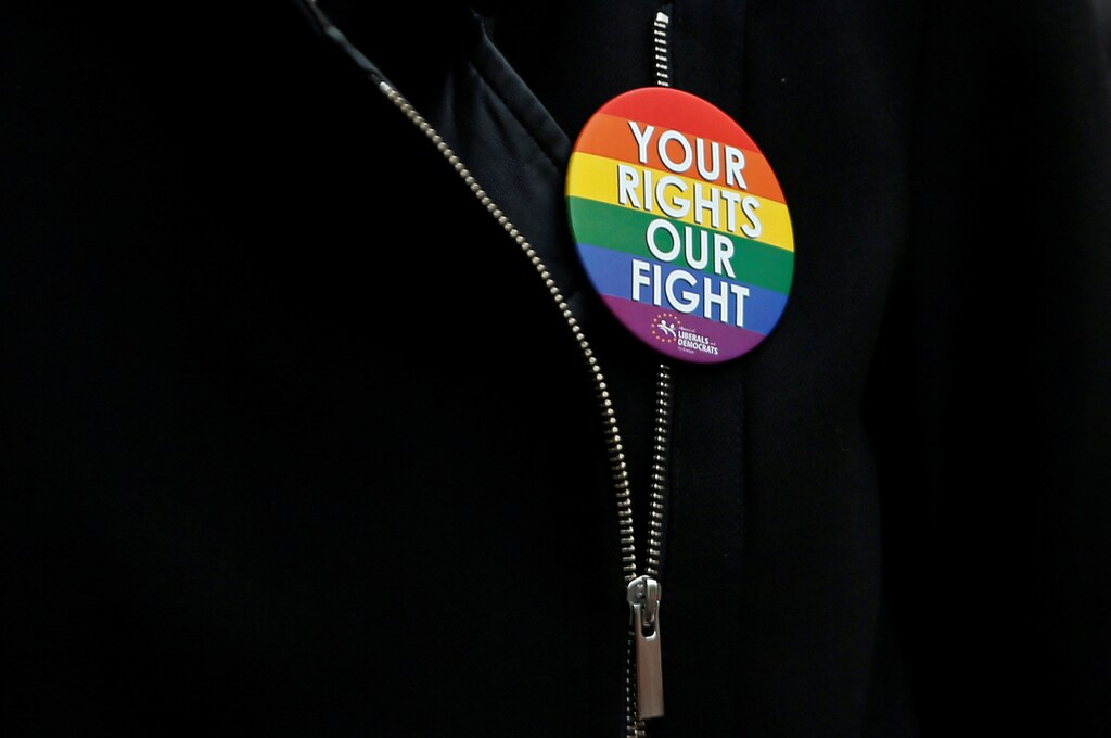 A woman wears a pin reading "Your rights our fight" during a vigil in memory of the victims of the gay nightclub mass shooting in Orlando, in central Brussels, Belgium June 14, 2016. REUTERS/Francois Lenoir - RTX2G8OL