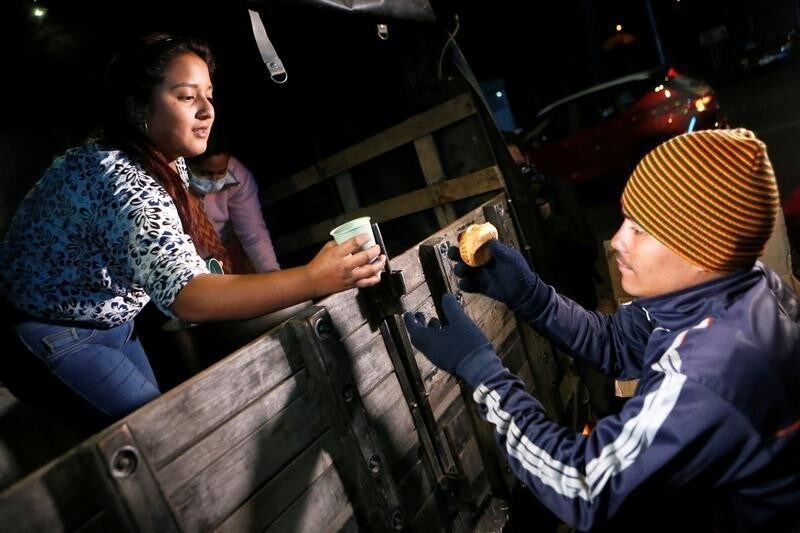 Colombians give food to Venezuelan migrants at the Rumichaca International Bridge, in Tulcan, Ecuador August 18, 2018. Picture taken August 18, 2018. REUTERS/Luisa Gonzalez - RC1948F07270