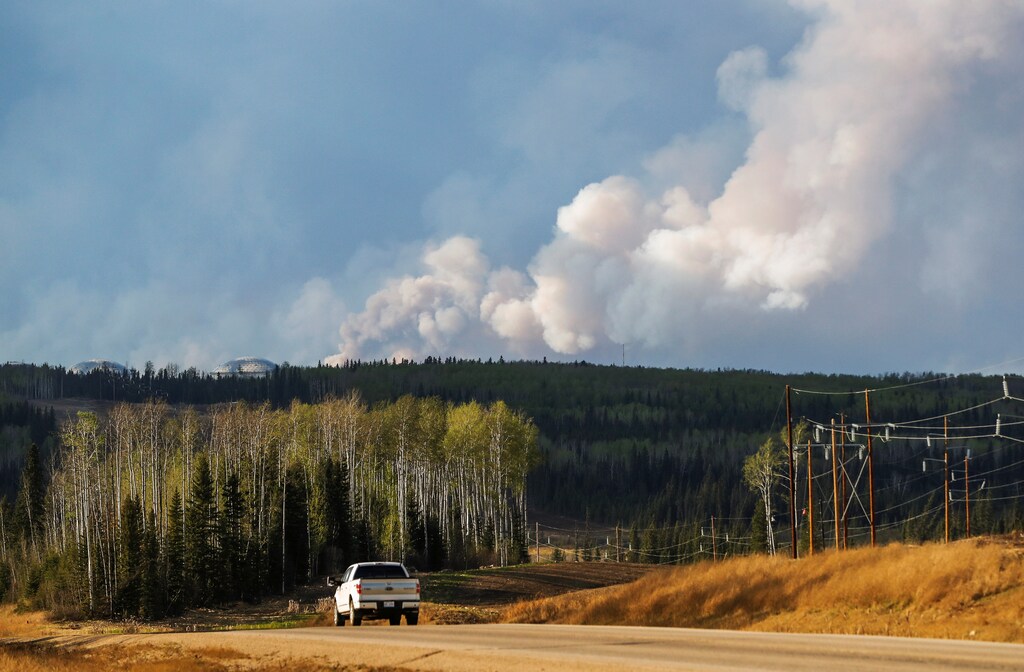 Smoke billows from the Fort McMurray wildfires as truck drives down the highway in Kinosis, Alberta, Canada, May 5, 2016. REUTERS/Mark Blinch - RTX2D1IV