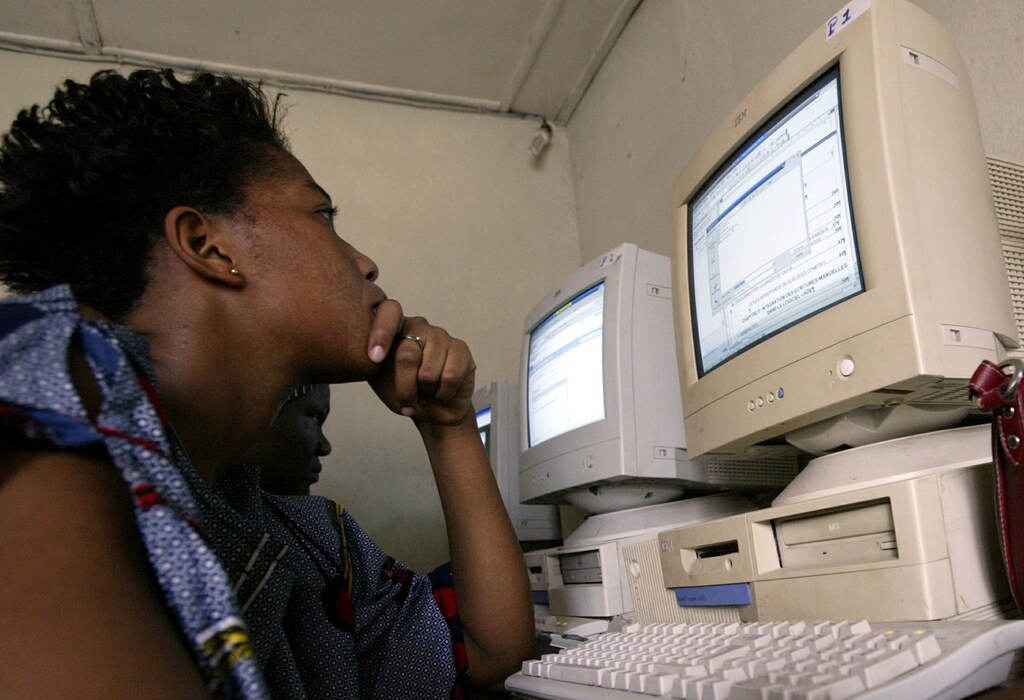 A girl looks the screen of a computer as she works in a cybercafe in Abidjan on November 18, 2005. - RTXNZOA