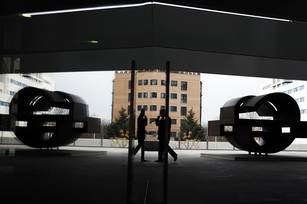 A man walks past the logo of Spanish oil major Repsol at its headquarters in Madrid February 26, 2015. Spanish oil group Repsol said its 2014 adjusted clean net profit jumped 27.1 percent, boosted by a big boost in refining margins that more than offset falling revenue in its production business amid plummeting world oil prices. REUTERS/Susana Vera (SPAIN - Tags: BUSINESS ENERGY LOGO) - RTR4R8YF