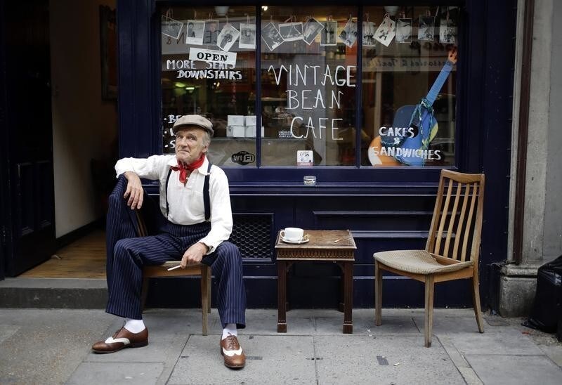 Mick, a genuine east end Cockney, sits with a cup of tea and a cigarette at a cafe near Brick Lane in London September 22, 2013. Mick supplements his state pension by dressing up and allowing himself to be photographed for a pound amongst the streets around Brick Lane that are lined with vintage shops. REUTERS/Kevin Coombs (BRITAIN - Tags: TRAVEL SOCIETY TPX IMAGES OF THE DAY) - GM1E99N08A001