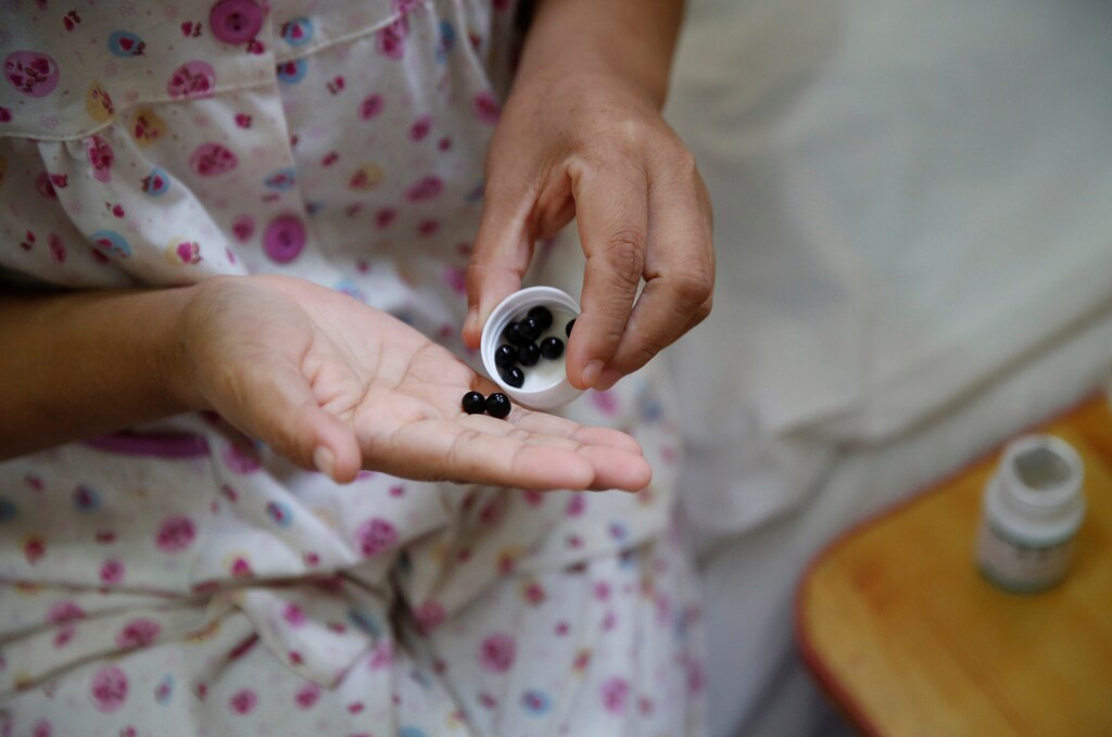 Wang takes her medicine at the accommodation where some patients and their family members stay while seeking medical treatments in Beijing, China, June 23, 2016. Wang, who suffers from cervical cancer, came from Inner Mongolia to seek treatment at a specialist hospital in Beijing. REUTERS/Kim Kyung-Hoon