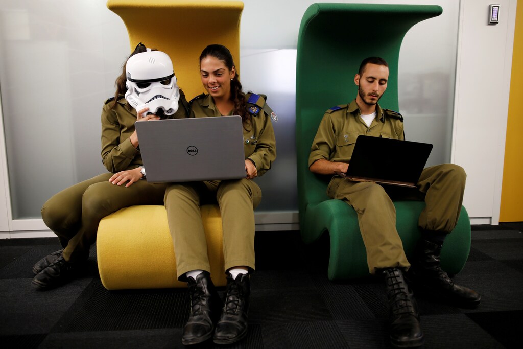 Israeli soldiers, one wearing a Star Wars Storm Trooper Voice Changing Helmet, work on laptops as they take part in a cyber security training course, called a Hackathon, at iNT Institute of Technology and Innovation, at a high-tech park in Beersheba, southern Israel August 28, 2017. Picture taken August 28, 2017. REUTERS/Amir Cohen TPX IMAGES OF THE DAY - RC17FB526740
