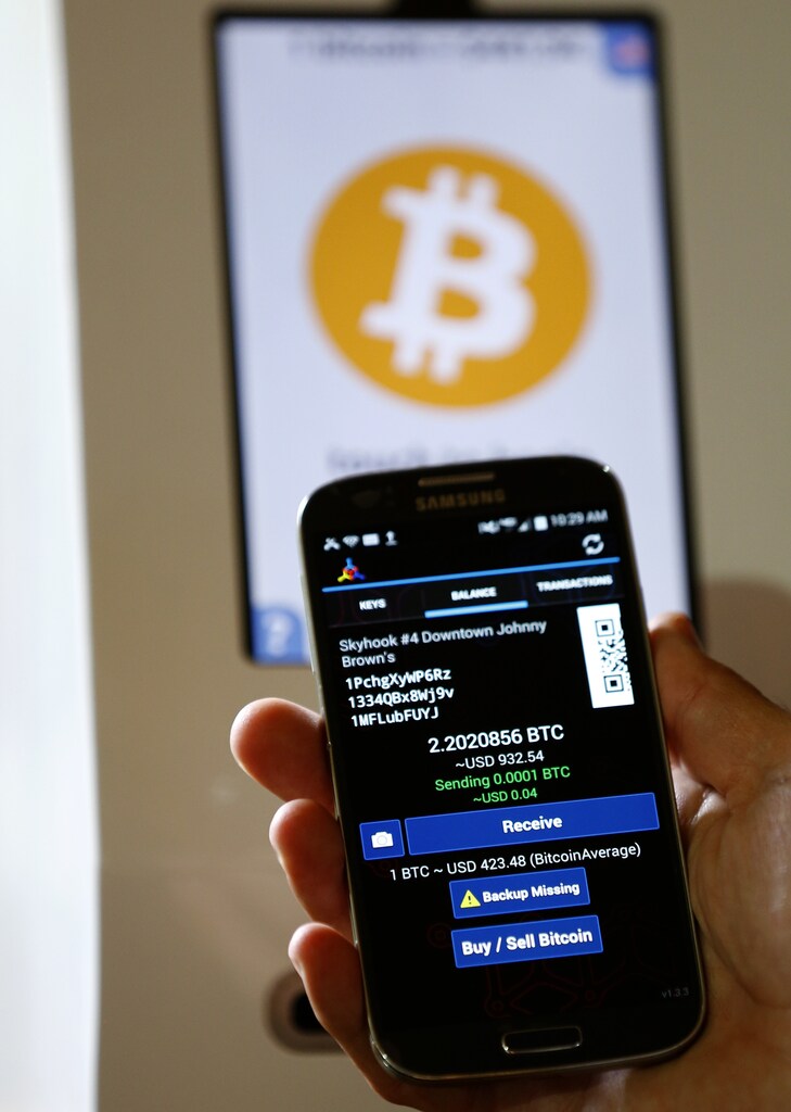 A mobile device is shown after cash was converted to bitcoins from a Bitcoin ATM machine (shown in the background) at a restaurant in San Diego, California September 18, 2014. The bitcoin ATM ingests cash enabling the user to convert their money to bitcoins via a QR code transfer to an application on their mobile device. REUTERS/Mike Blake (UNITED STATES - Tags: SOCIETY BUSINESS SCIENCE TECHNOLOGY) - GM1EA9J0BYU01
