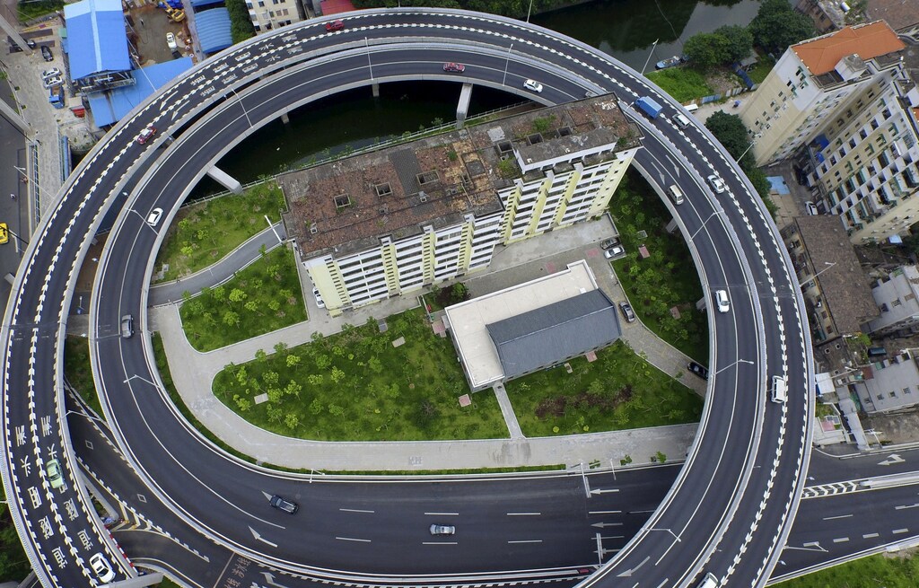 An old residential building is seen surrounded by a newly-built ring viaduct, in Guangzhou, Guangdong province, China, June 18, 2015.