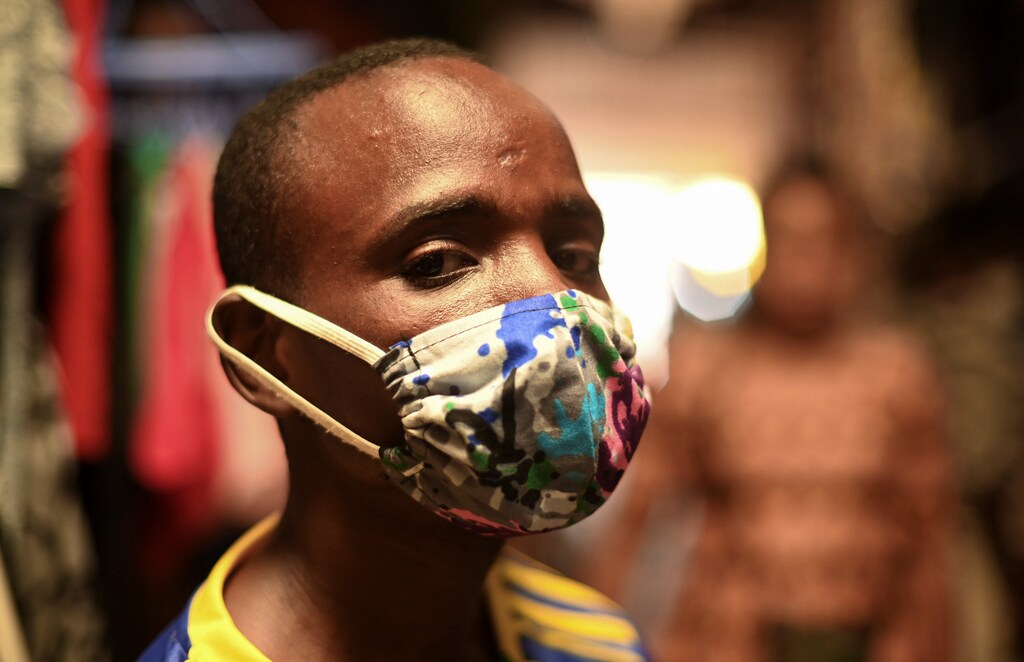 Eugene Amuri, a vendor at the Kimironko market wears a handmade "kitenge" cloth mask as he attempts to protect against the coronavirus disease (COVID-19), in Kigali, Rwanda March 17, 2020. REUTERS/Maggie Andresen - RC2TLF9JHIN5