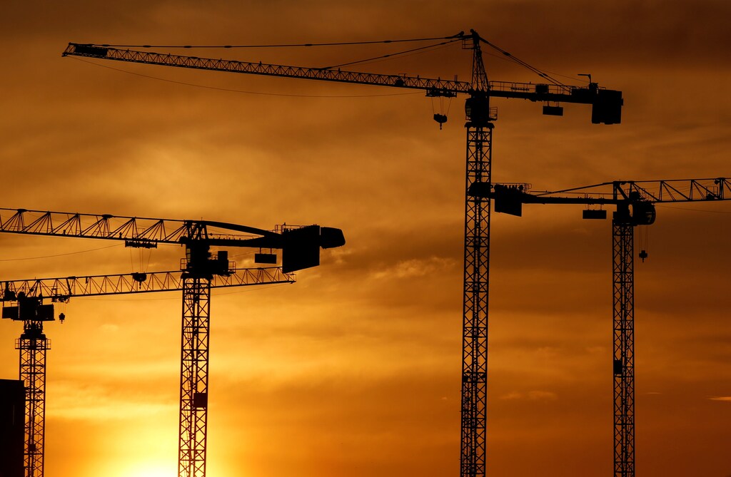 Cranes are seen at sunset at a construction site in Bordeaux, France, April 9, 2019. REUTERS/Regis Duvignau - RC1F4FB022A0