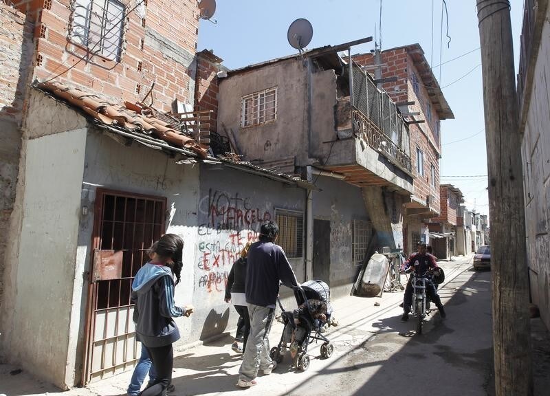 Locals walk on a street at the Villa Soldati slum in Buenos Aires September 26, 2014. According to a report issued by the NGO Civil Association for Equality and Justice (ACIJ) there are 14 slums and 24 settlements in Buenos Aires where approximately 275,000 people live, or nearly ten percent of the city's population of three million. The ACIJ said that the slums infrastructure and access to emergency assistance are not enough to transform them into proper neighborhoods, and there is no place to move the inhabitants to places with better living conditions.