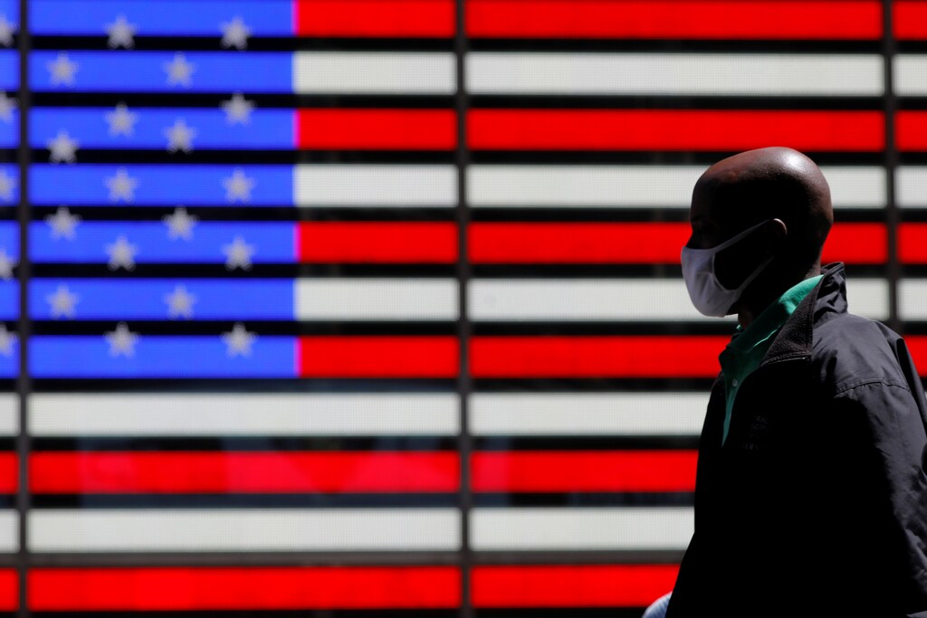 A person walks in Times Square after the Centers for Disease Control and Prevention (CDC) announced new guidelines regarding outdoor mask wearing and vaccination during the outbreak of the coronavirus disease (COVID-19) in Manhattan, New York City, New York, U.S., April 27, 2021. REUTERS/Andrew Kelly - RC2I4N9JL43A