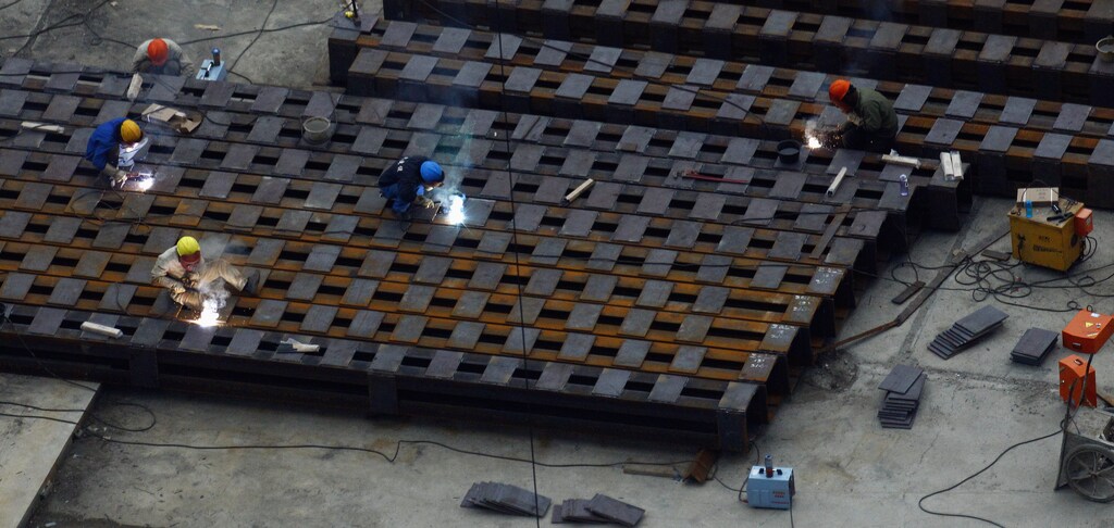Workers weld steel bars at a construction site in downtown Shanghai, March 19, 2013. China is poised to launch its most serious economic reform drive since the 1990s after a series of top appointments at the weekend put the architects of Zhu Rongji's clash with state owned enterprises in charge of key economic agencies. REUTERS/Carlos Barria (CHINA - Tags: ENERGY BUSINESS CONSTRUCTION) - RTR3F6D0