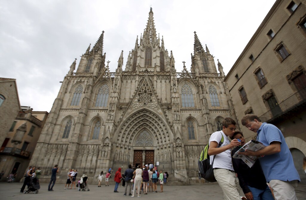 A family looks at a map in front of Barcelona's cathedral at Gothic quarter in Barcelona, Spain, August 18, 2015.