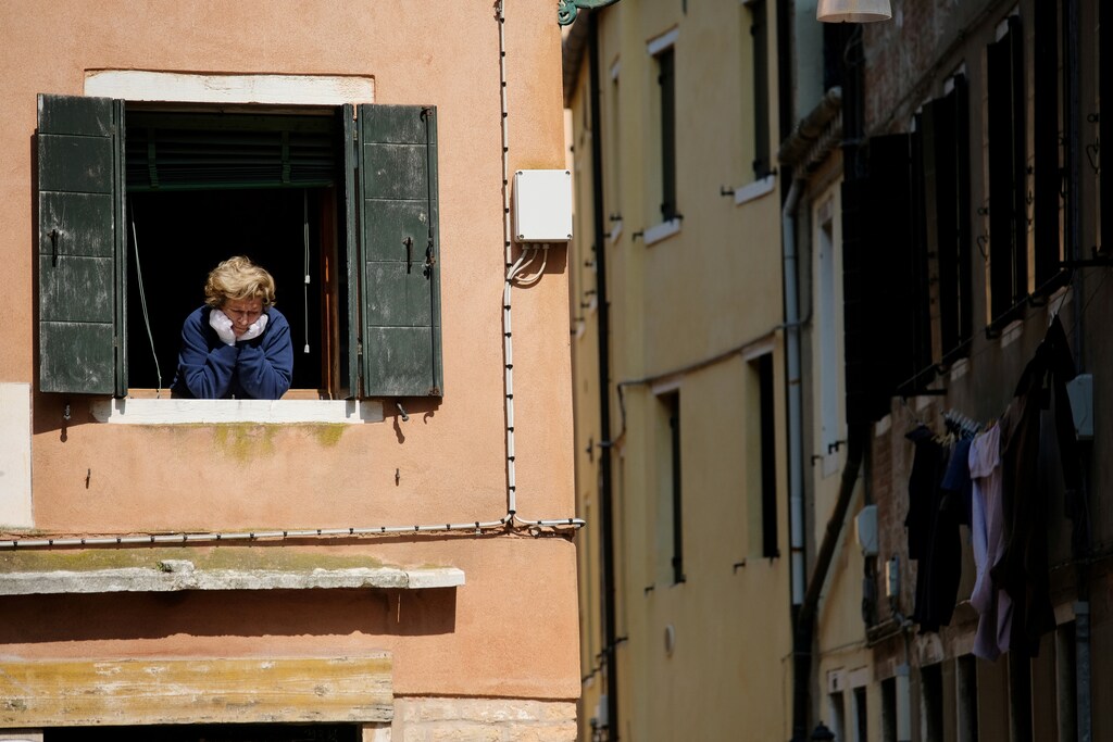 A woman looks out of an apartment window as Italians remain under lockdown to prevent the spread of the coronavirus disease (COVID-19) in Venice, Italy April 4, 2020.