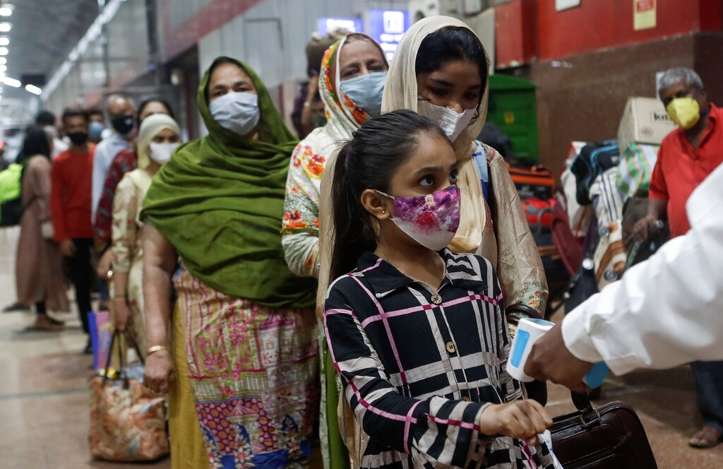 Passengers wait in line to get their temperature checked at a railway station, amid the spread of the coronavirus disease (COVID-19), in Mumbai, India November 26, 2020. REUTERS/Francis Mascarenhas - RC2XAK92D1AC
