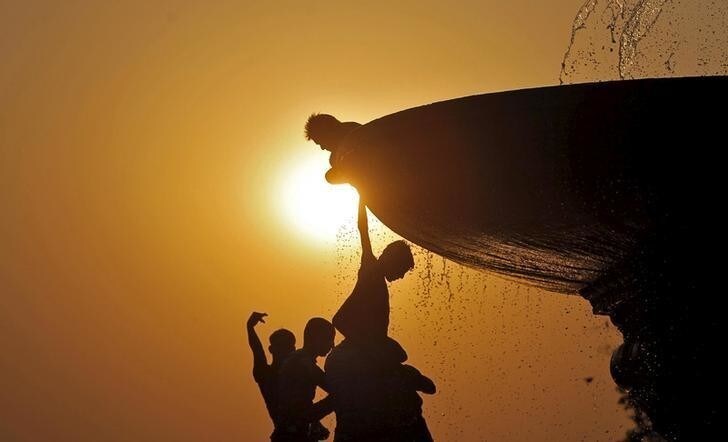 Boys cool off under a water fountain on a hot summer evening in New Delhi, India, April 25, 2016. REUTERS/Anindito Mukherjee TPX IMAGES OF THE DAY