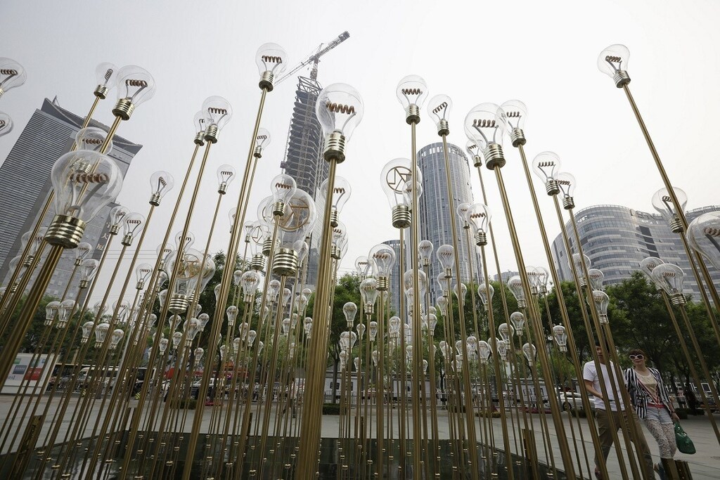 A couple walk past "Filament Lamp", an art work installation, at a commercial center near a construction site in Beijing's Sanlitun area May 7, 2013. REUTERS/Jason Lee