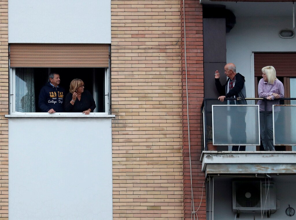 People look out of their apartment windows as part of a flashmob organised to raise morale during Italy's coronavirus crisis in Rome, Italy, March 13, 2020. REUTERS/Yara Nardi - RC27JF9PW2ST