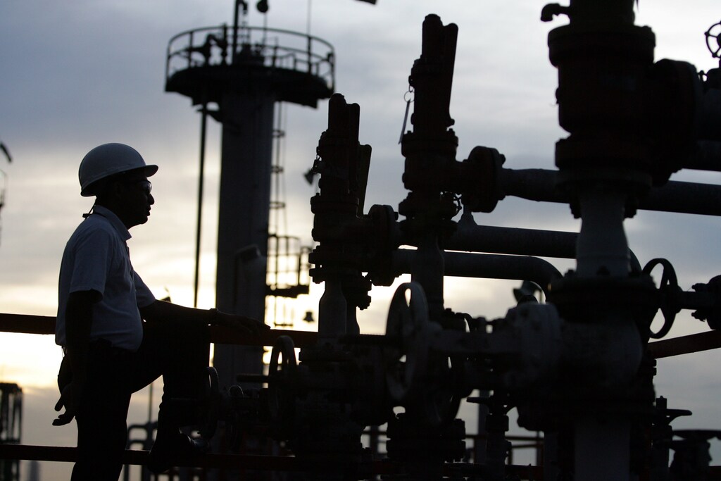 A technician checks pipelines at Bangchak oil tanks in Bangkok September 7, 2005.