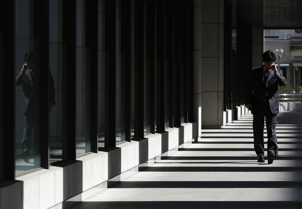 A man scratching his face walks down a corridor in Tokyo April 7, 2014. The Bank of Japan is expected to hold off on expanding stimulus on Tuesday, holding fast to existing plans to beat chronic deflation even as a sales tax hike clouds the outlook for the world's third-largest economy. Picture taken April 7, 2014. REUTERS/Yuya Shino (JAPAN - Tags: POLITICS BUSINESS) - RTR3KBYX