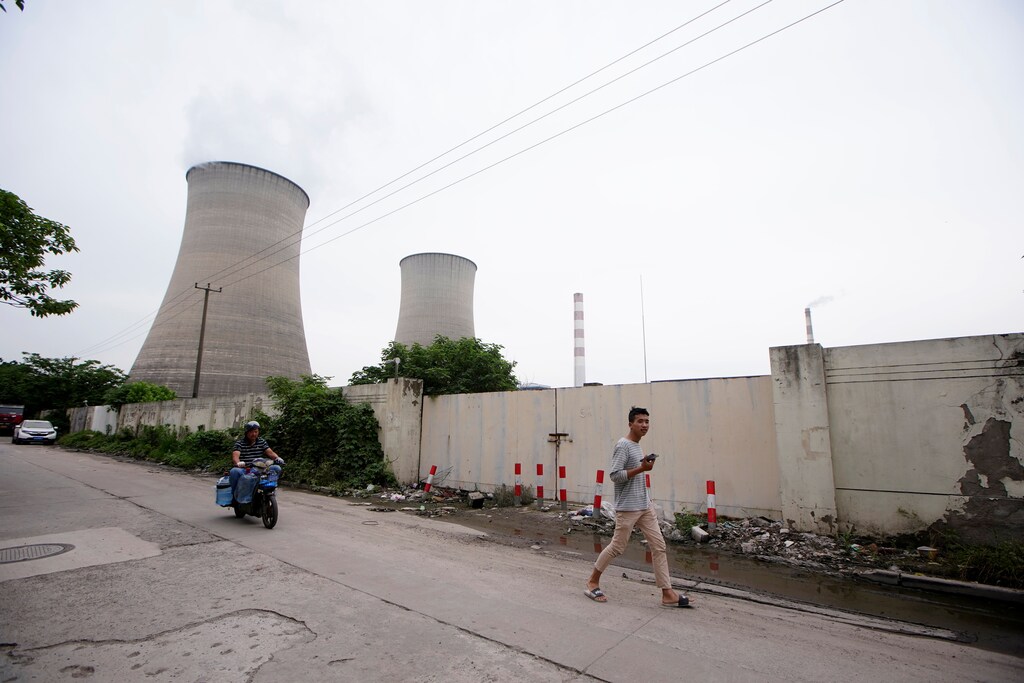 A man walks past a coal-fired power plant in Shanghai, China, May 28, 2021. REUTERS/Aly Song - RC2QON9HKV21