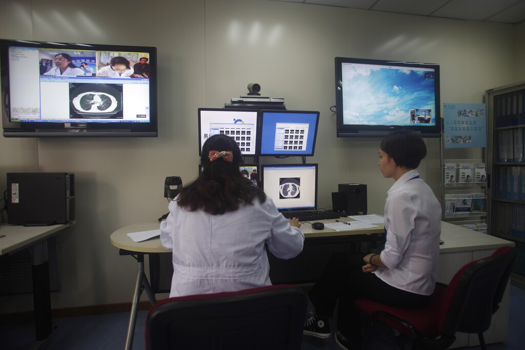 Doctors diagnose a patient remotely at the First Hospital of Zhejiang Province in Hangzhou, Zhejiang province, September 24, 2014. Technology is playing a growing role as Beijing overhauls a healthcare management sector blighted by chaotic patient data, underfunded rural health centres, overburdened city hospitals and a nationwide shortage of doctors. Government-supported programs are looking to leverage specialised software and communication equipment to get the most out of in-demand doctors and specialists at leading hospitals. China's healthcare management sector is growing at close to 40 percent a year and will hit $38 billion in the next five years, according to local consultancy Raisewin International. Picture taken September 24, 2014. To match CHINA-HEALTHCARE/DIGITAL. REUTERS/Adam Jourdan (CHINA - Tags: HEALTH SCIENCE TECHNOLOGY) - RTR4A7C5