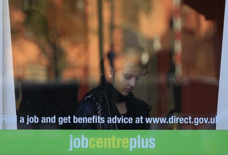 A woman enters an employment centre in Leicester, central England, October 20, 2010. Britain will take an axe to its welfare state on Wednesday as part of an 80 billion-pound ($125 billion) cut in public spending that will dictate the future of of both the economy and the coalition government. REUTERS/Darren Staples (BRITAIN - Tags: EMPLOYMENT BUSINESS POLITICS) - LM1E6AK0S8K01