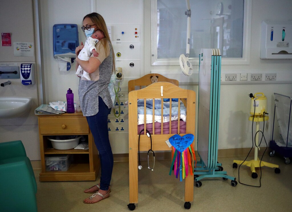 Kirsty Anderson holds her baby Theo, who was born prematurely and is now nine weeks old, as they wait for medical staff to discharge him from hospital in the Lancashire Women and Newborn Centre of Burnley General Hospital in East Lancashire, following the spread of the coronavirus disease (COVID-19) in Burnley, Britain, June 22, 2020. Picture taken June 22, 2020. REUTERS/Hannah McKay - RC2KFH9AI8TW
