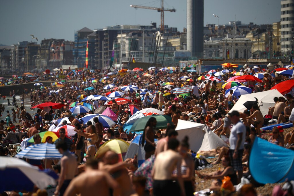 People enjoy the hot weather at the beach in Brighton, Britain, June 25, 2020. REUTERS/Hannah McKay - RC2DGH97DP5P