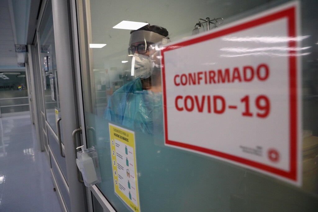 A health worker takes care a patient (not pictured) infected with the coronavirus disease (COVID-19) inside an Intensive Care Unit of the Posta Central hospital in Santiago, Chile, June 9, 2020. Picture taken June 9, 2020. The sign reads 'COVID-19 Confirmed' REUTERS/Ivan Alvarado - RC2BHH9R4JCI
