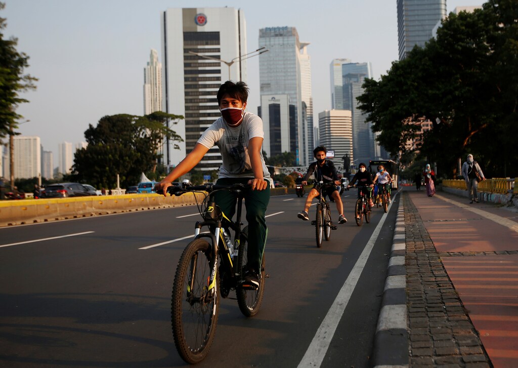 Youths ride bicycles on the main road after the government eased restriction measures following the coronavirus disease (COVID-19) outbreak in Jakarta, Indonesia, June 29, 2020. REUTERS/Willy Kurniawan - RC22JH9CEU4C