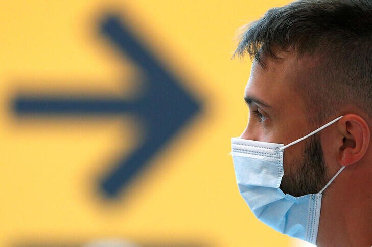 A passenger wearing a protective face mask waits for his flight at Fiumicino Airport, one of the two airports in the world to obtain the 'Biosafety Trust certification' for the correct application of security measures to prevent infections, following the coronavirus disease (COVID-19) outbreak, in Rome, Italy June 30, 2020. REUTERS/Guglielmo Mangiapane