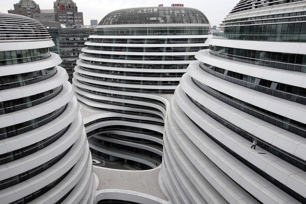 A worker cleans an exterior of a newly built urban complex building accommodating offices and retail shops in Beijing October 14, 2013. REUTERS/Kim Kyung-Hoon (CHINA - Tags: BUSINESS CONSTRUCTION TPX IMAGES OF THE DAY) - GM1E9AE1BGU01