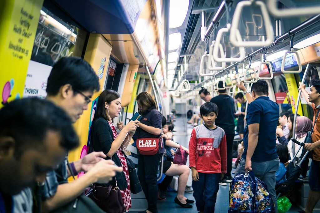 アジアの混み合った地下鉄車内の写真。シンガポールはパブリックセクター向けエージェント型AIの導入に成功した数多くの国の一つです。