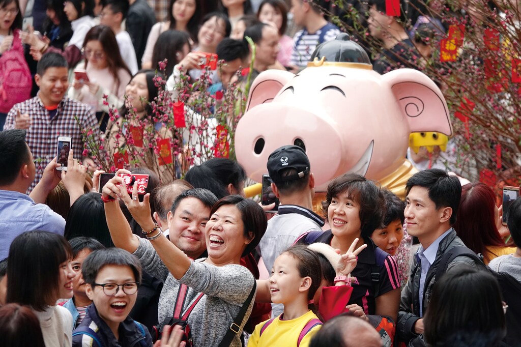 Visitors take pictures of an installation at a flower fair ahead of the Chinese Lunar New Year of the Pig, in Guangzhou, Guangdong province, China February 3, 2019. Picture taken February 3, 2019. REUTERS/Stringer ATTENTION EDITORS - THIS IMAGE WAS PROVIDED BY A THIRD PARTY. CHINA OUT. - RC137BD315B0