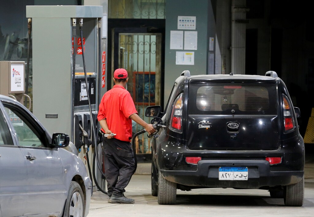 A worker fills the car as people queue and wait in their cars at a Total petrol station early on Friday, after the central bank floated the pound currency, in Cairo, Egypt, November 4, 2016. REUTERS/Amr Abdallah Dalsh - D1BEUKWBECAB